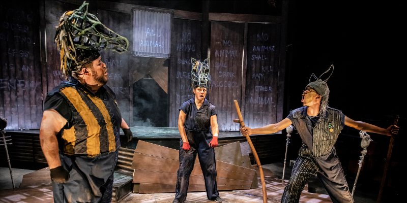 3 actors on stage wearing head costumes for Animal Farm performance. Photo by Pamela Raith Photography 