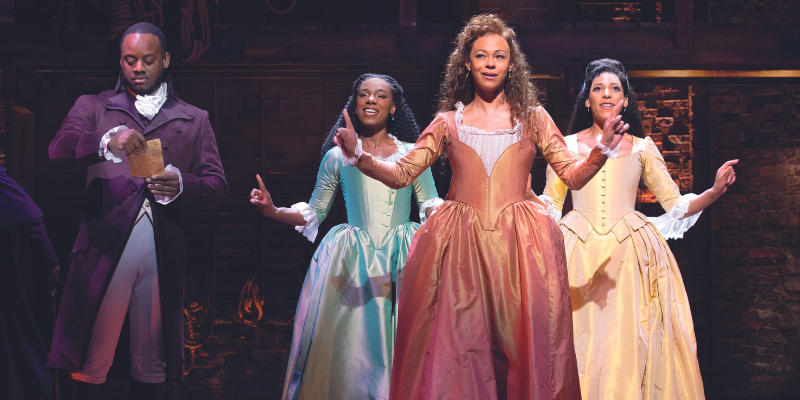 Shan Ako as Eliza Hamilton, Ava Brennan as Angelica Schuyler and Simbe Akande as Peggy Schuyler on stage for Hamilton
